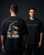 Still Here. Still Building — Oversized Tee